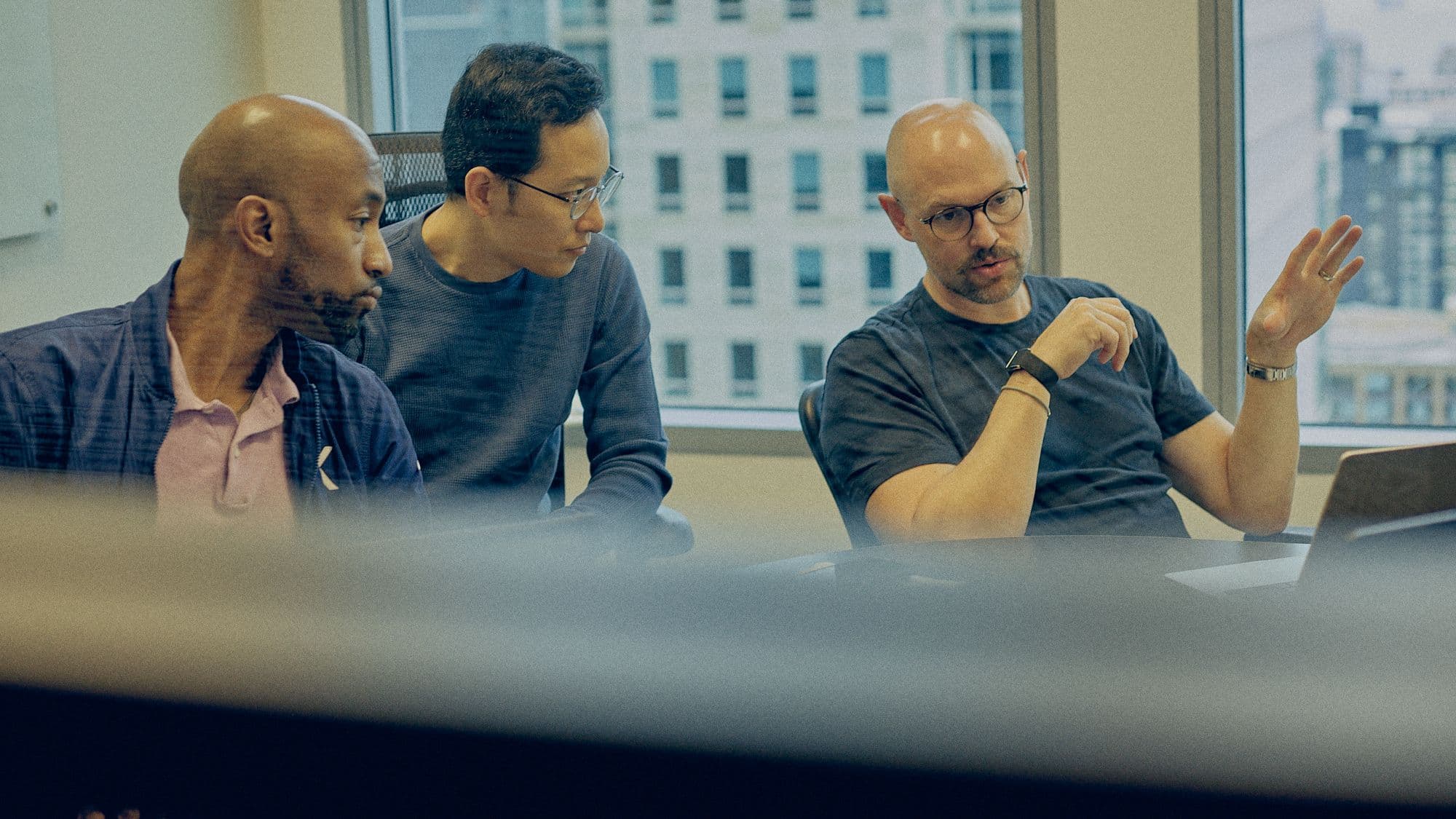 Three Within team members in discussion around a conference table